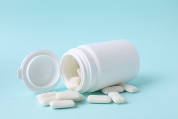 Jar with chewing gums on light blue background, closeup