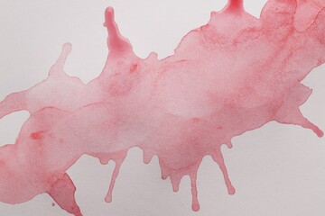 Pink watercolor blots on white canvas, top view