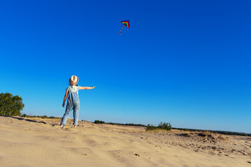 Obraz premium little girl playing with kite in the desert.