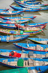 Fototapeta na wymiar Elevated view of blue fishing boats all tied together in a line