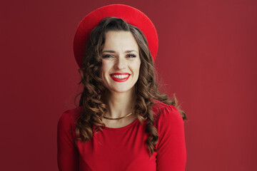 happy elegant woman in red dress and beret isolated on red