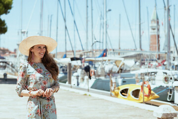 happy young tourist woman in floral dress on pier