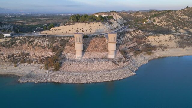 Aerial shot of two towers on  Embalse de la Pedrera reservoir Orihuela, Spain.  Drone video footage bullet shot.