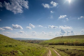 Fototapeta na wymiar Panorama of Titelski breg, or titel hill, in Vojvodina, Serbia, with a dirtpath countryside road, in an agricultural landscape with blue sky. ....