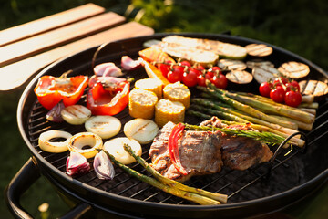 Delicious grilled vegetables and meat on barbecue grill outdoors, closeup