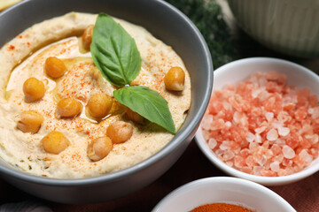 Fototapeta na wymiar Delicious creamy hummus with chickpeas and ingredients on table, closeup