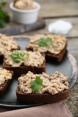 Tasty sandwiches with cod liver and parsley on wooden table