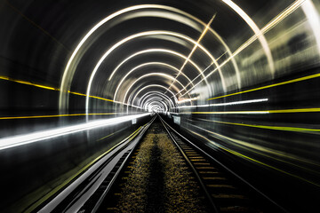 High speed subway travel underground with yellow and white light trails. Train in motion