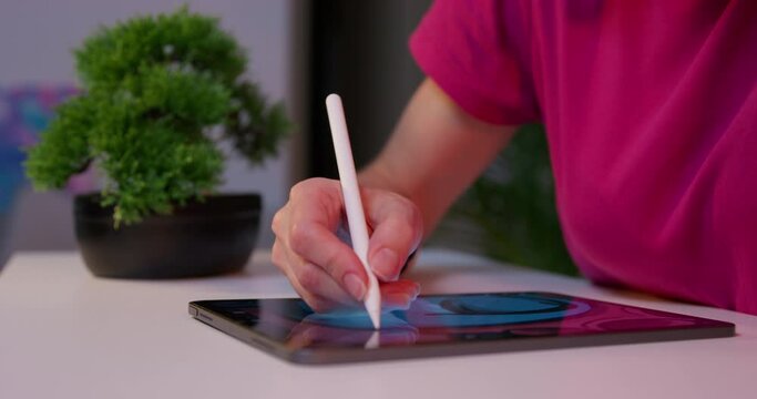 Digital drawing training. Woman freelancer illustrator draws with pencil on tablet while sitting at cozy workplace in home office. Hand with stylus drawing picture confident gesture across screen