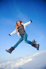 Fototapeta na wymiar Pretty young woman with red hair take a fun on the snow field