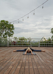 A woman doing yoga at rooftop hotel in Jimbaran, Bali, Indonesia.