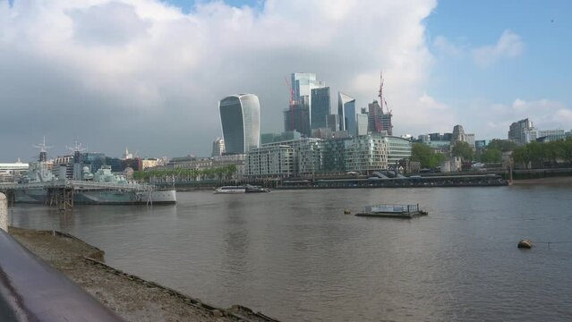 A clip of a London city skyline. Shot over the river Temse. Looking at the skyscrapers in the background with a warship on the left and the Tower of London on the right.
