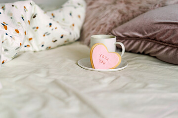 A cup of coffee with delicious cookies with the inscription love you. Celebrating Valentine's Day at home. Concept of Valentine's Day