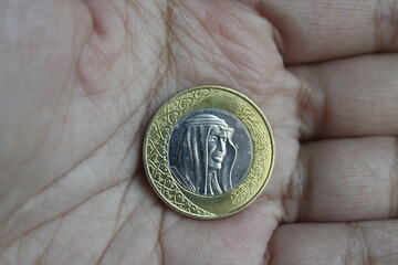 riyal coin in someone's hand