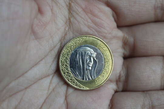 riyal coin in someone's hand