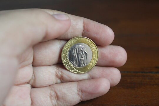 riyal coin in someone's hand