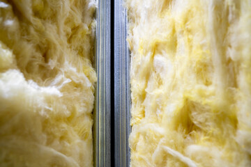 Glass wool between metal profiles in the wall. Universal insulation material for sound and heat...