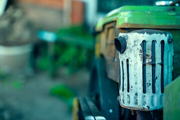 The muffler of the exhaust pipe of a walk-behind tractor against the background of a small diesel...