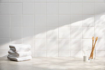 front view of bathroom with white tile wall, various bath objects, and sunlight. copy space.