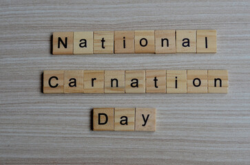 National Carnation day text on wooden square, holiday concept quotes