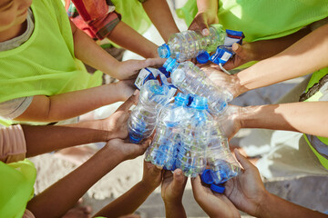 Children, hands and plastic bottles in beach waste management, community service or climate change...