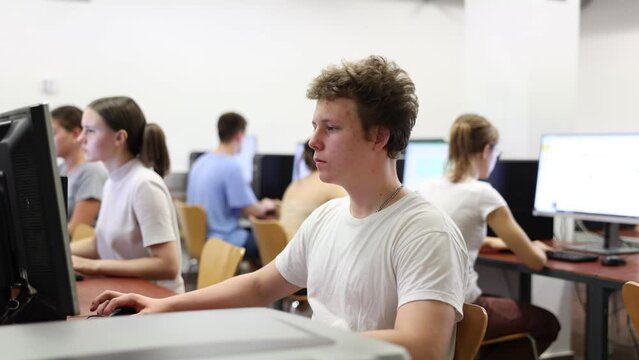 Clever focused male teenager solving tasks of computer science in the auditory