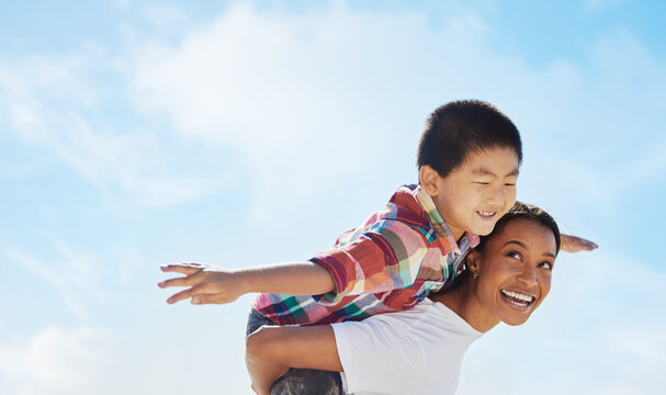 Mom, piggyback airplane and child by sky with smile, family bonding or outdoor vacation in summer. Happy family, interracial and black woman back for asian adoption, love or game on holiday adventure