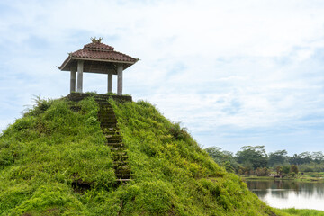 A lone pavilion on the top of a hill, with some bulls sculpture on the of it