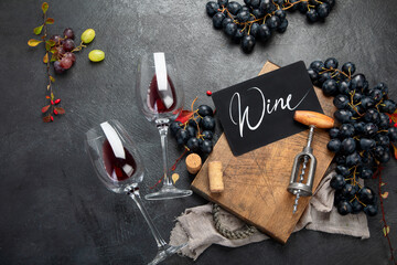 Bottle of red wine with a corkscrew. On a dark background.