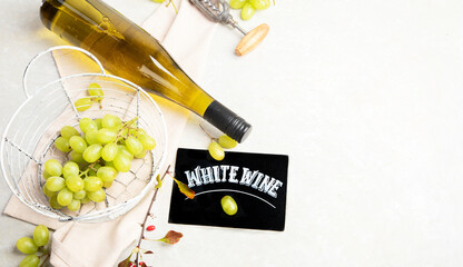 Glasses and bottle with white wine on a white background.
