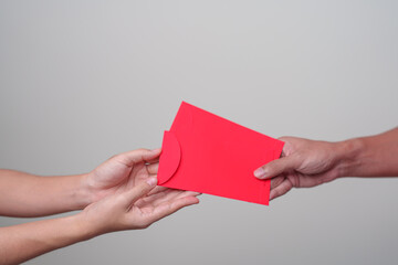 People hand giving Chinese red envelope, money gift for happy Lunar New Year holiday
