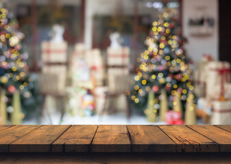 Empty wood table with decorated christmas tree with shiny lights in blurred abstract winter landscape, christmas background for product display