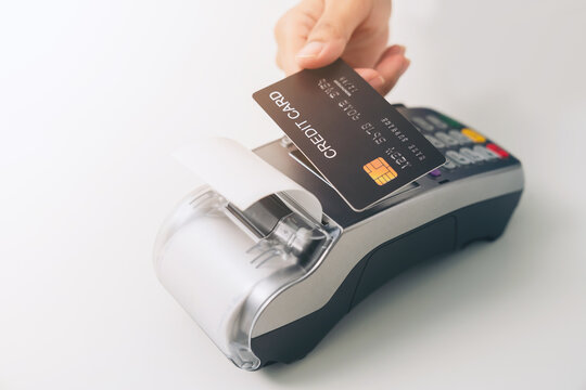 Customer using credit card for payment by NFC technology on card reader machine.