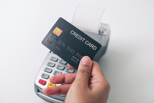 Customer using credit card for payment by NFC technology on card reader machine.