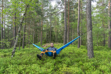 A young man hiker having a rest in a hammock.