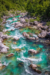 Fototapeta na wymiar Soca Valley, Slovenia - Aerial view of the emerald alpine river Soca on a bright sunny summer day with green foliage. Whitewater rafting in Slovenia
