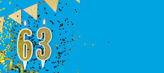 Golden candle number sixty three. Birthday or anniversary card with the inscription 63 on blue background. Anniversary celebration. Banner.