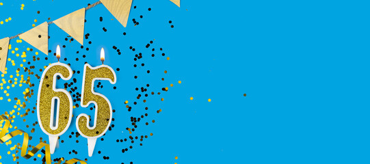 Golden candle number sixty five. Birthday or anniversary card with the inscription 65 on blue background. Anniversary celebration. Banner.