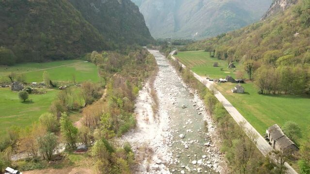 Aerial View Of Maggia River Flowing Down On the Village Of Bignasco, Vallemaggia, Canton of Ticino, Switzerland. 