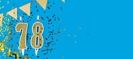 Golden candle number seventy eight. Birthday or anniversary card with the inscription 78 on blue background. Anniversary celebration. Banner.