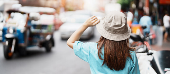 Young Woman with hat traveling in Bangkok, Asian traveler visiting at Yaowarat road or Chinatown of Bangkok, landmark and popular for tourist attractions in Thailand. Southeast Asia Travel concept