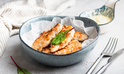 Homemade chicken strips on a light concrete background, selective focus