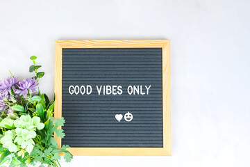 Letter board with phrase Good vibes only white background, flowers with heart. Concept of mental health. Aspiration, supportive sentence, law of attractions, affirmatives, subconscious mind, NLP.