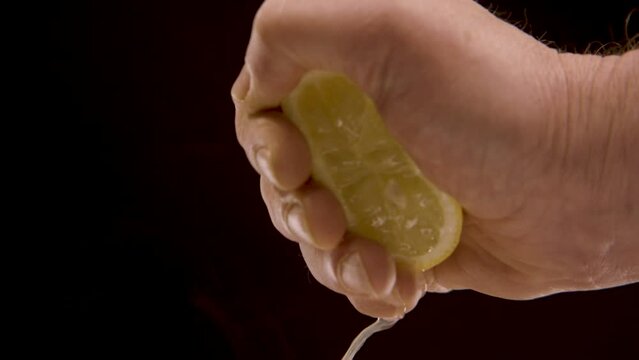 eine Hand dr&uuml;ckt eine Zitrone aus