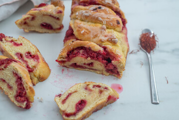 Sweet home made saffron babka brioche with raspberries on a table