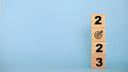 2023 Happy New year background banner. 2023 year numbers on wooden cube blocks stack on blue background with copy space. Concept of planning, goal, challenge, new year resolution..