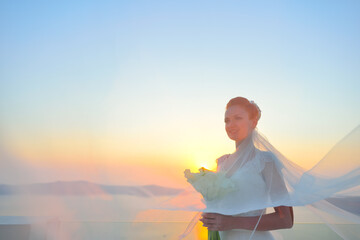 Pretty woman posing in white wedding dress on Santorini island, Greece
