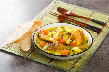 Ca Ri Ga Vietnamese Coconut Chicken Curry with vegetables close-up in a plate on the table. Horizontal