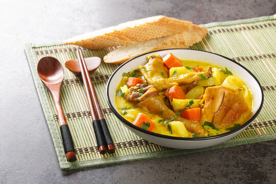 Ca ri ga is a deliciously fragrant yet mild Vietnamese chicken curry infused with fresh herbs and spices close-up in a plate on the table. Horizontal