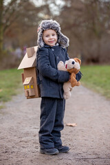 Little child, blond boy with pet dog, carying home on his back, kid, having paper house